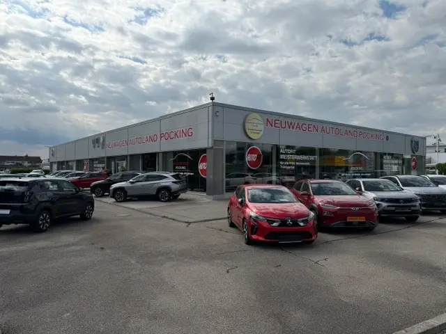 Das Autohaus von draußen fotografiert. Es stehen Autos davor